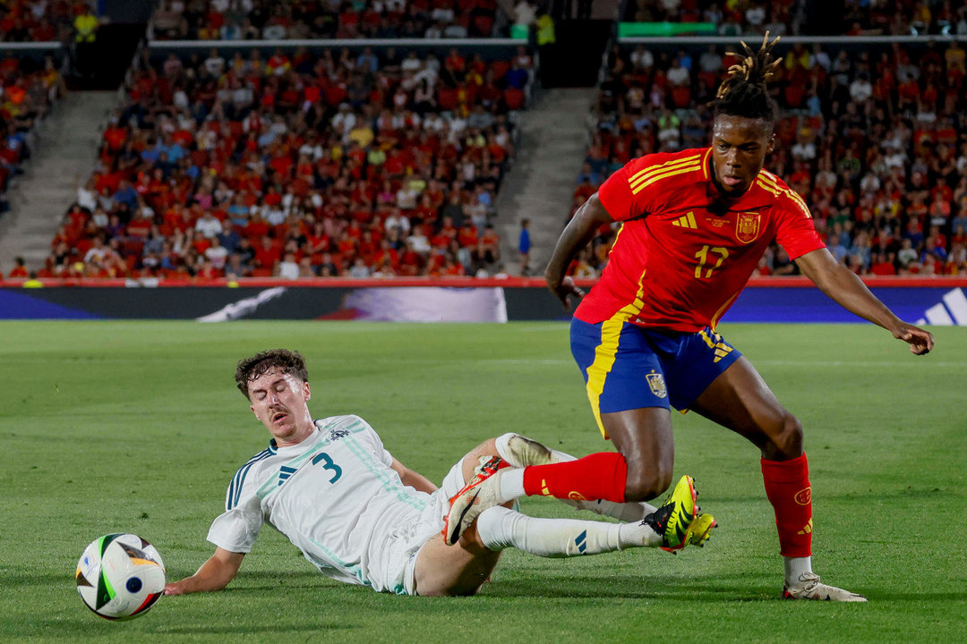 El delantero de la selección española Nico Williams (d) trata de escapar de Trai Hume, de Irlanda del Norte, durante el partido amistoso de fútbol disputado este sábado en el estadio de Son Moix. EFE/Cati Cladera