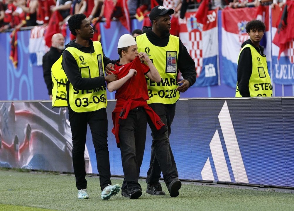 La seguridad saca del campo a un hincha de Albania en el estadio en Hamburgo, Alemania. EFE/EPA/ROBERT GHEMENT