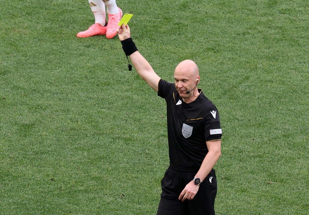 El árbitro Anthony Taylor muestra una tarjeta amarilla durante el partido de fútbol de la Eurocopa 2024 entre Ucrania y Bélgica, en Stuttgart, Alemania. EFE/EPA/MOHAMED MESSARA